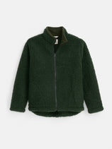 The Coldbreaker Walker Jacket is a dark green fleece with a high collar, zip closure, and long sleeves. Made from 100% Irish wool, its textured, sherpa-style fabric provides exceptional warmth and comfort. Designed by Coldbreaker in unisex sizing, the jacket is shown against a plain white background.