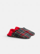 The Wool Plaid House Shoes are soft, machine washable slippers featuring a dark plaid pattern and vibrant red heel cuffs, showcased on a plain light background.