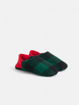 The Buffalo Check House Shoe features a soft, machine-washable design with a green and black checkered pattern and bold red heels, shown on a white background.