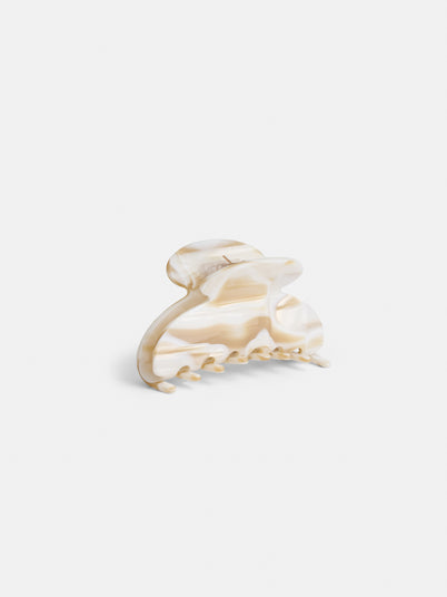 The Large Round Claw is a beige and cream marbled acetate hair clip with a curved, rounded top and interlocking teeth, handcrafted in France, shown against a plain white background.