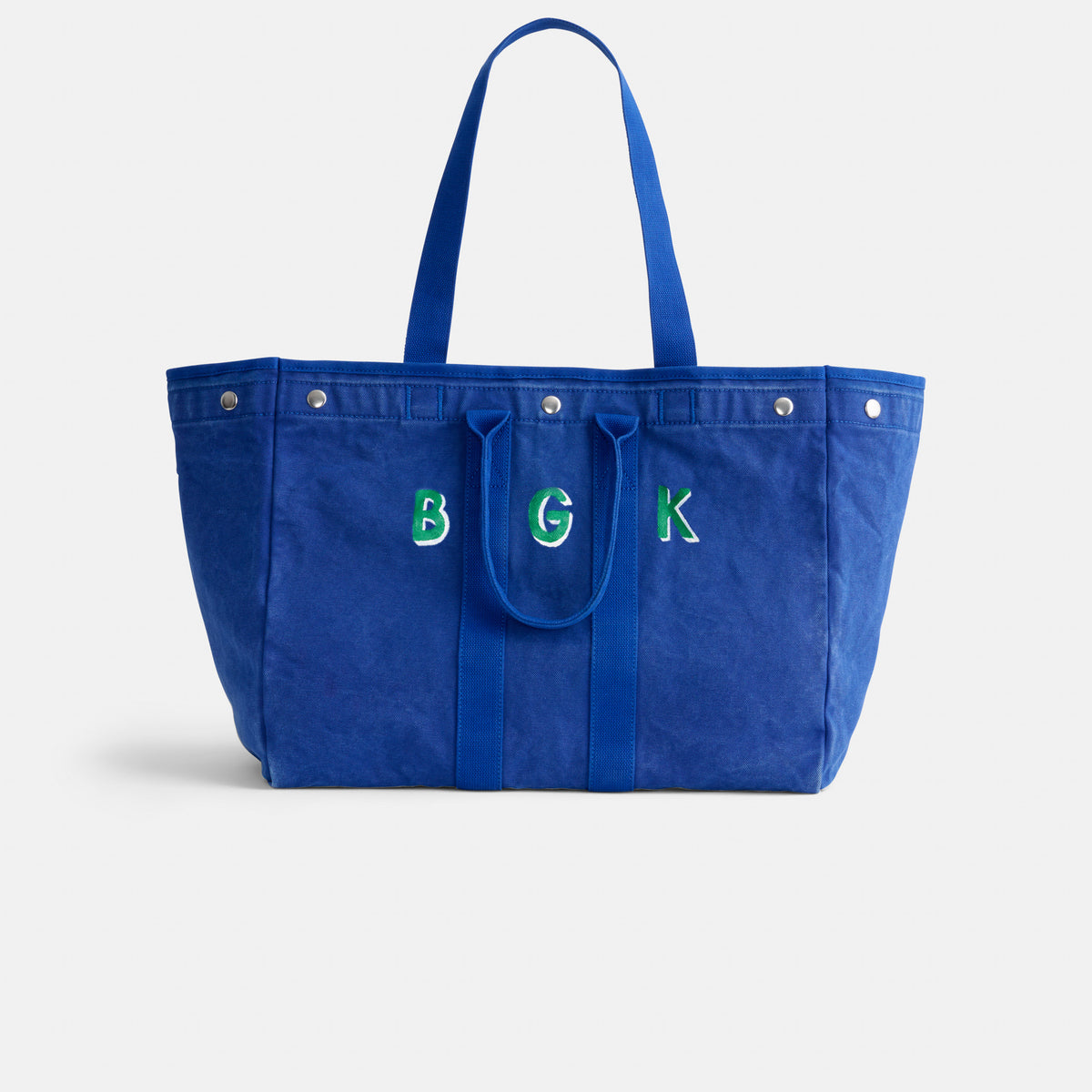 The Perfect Weekend Tote is a large blue cotton bag with two handles and green-and-white embroidered "B G K" letters on the front—ideal for monogram lovers.