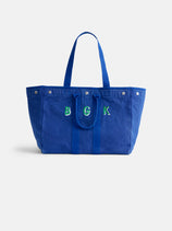 The Perfect Weekend Tote is a large blue cotton bag with two handles and green-and-white embroidered "B G K" letters on the front—ideal for monogram lovers.