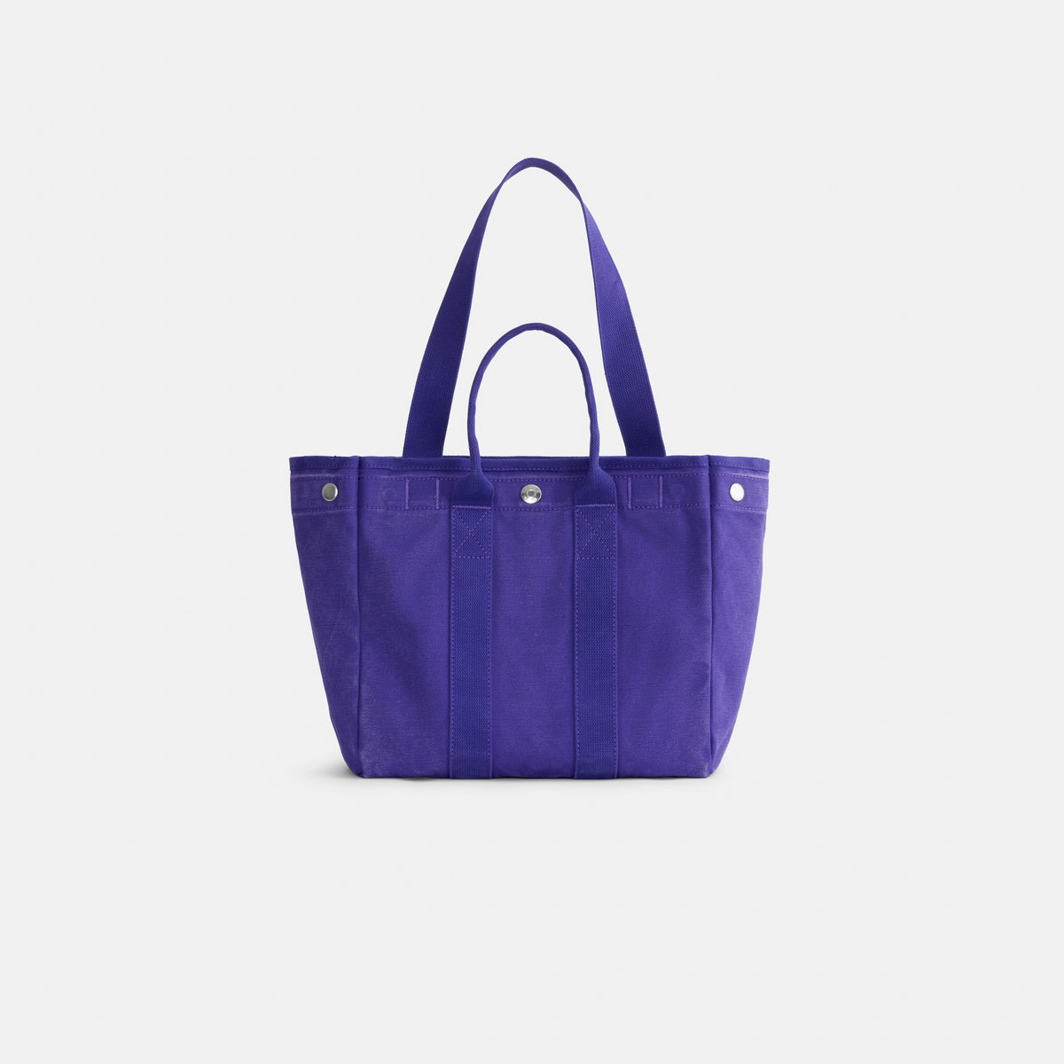 The Perfect Daily Tote, crafted from bright purple cotton, features two short handles and a snap closure, displayed against a plain white background.