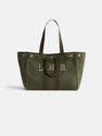The Painted Perfect Weekend Tote is a large olive green canvas bag with dark brown handles, silver-tone snap buttons, and "LHR" stitched in white on the front, shown against a plain white background.