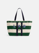 The Perfect Striped Weekend Tote features wide green and white canvas stripes, dark handles, and bold blue "L K B" letters on the front, set against a plain white background.