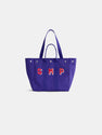 Introducing the Painted Perfect Weekday Tote—a purple bag with two handles and silver rivets, adorned with bold red and white “SMP” lettering on the front. This stylish accessory is perfect for anyone who loves personalized totes and monogrammable bags.