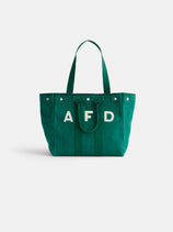 The Painted Perfect Weekday Tote is a green canvas bag with two handles and bold white A F D block letters on the front, shown against a plain white background.
