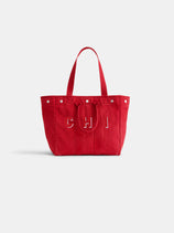 The Painted Perfect Weekday Tote is a red canvas bag with two handles, silver button accents, CHI in white letters on the front, and vertical stitching. The product is displayed against a plain white background.