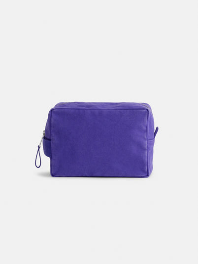 The Painted Perfect Dopp Kit—a rectangular purple zippered canvas pouch with a small side handle— is displayed against a plain white background and is perfect as a makeup bag or personalized toiletry bag for everyday essentials.
