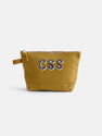 The Painted Perfect Canvas Pouch is a mustard yellow zippered pouch with a small side handle. "CSS" is embroidered in large blue and white letters on the front. Shown against a plain white background.