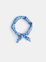 The Alex Mill x Liberty Bandana features a blue and white floral print in 100% cotton Liberty Fabric, tied simply and shown on a plain white background—a stylish summer accessory.