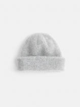 The Beanie In Brushed Cashmere is a soft, light gray knit beanie with a folded brim, shown against a plain white background.