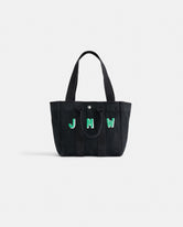 The Perfect Daily Tote is a black cotton bag with two handles, showcasing green and white 