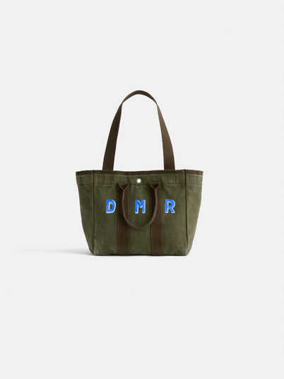 The Perfect Daily Tote: a green cotton bag with brown handles, showcasing DMR initials in blue and white on the front. Photographed against a plain white background, this chic tote is ideal for everyday use.