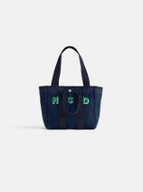 The Perfect Daily Tote is a navy blue cotton bag with two handles, featuring green and white embroidered "M S D" letters on the front—ideal for personalization. Displayed against a plain white background.