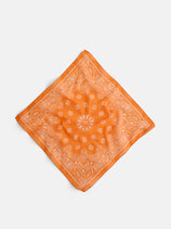 The Two Tone Bandana in Cotton, an orange vintage piece made in Italy with a white paisley pattern, is laid flat on a light gray background.