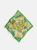 The State Bandana In Cotton Voile is a colorful square scarf featuring illustrated Maine landmarks, sailboats, and scenery, with a green border and MAINE at the top center—soft cotton voile inspired by vintage bandanas.