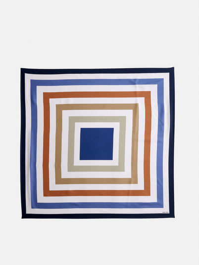 Pop Art Silk Scarf featuring concentric squares in blue, beige, white, and rust on a white background, finished with a dark blue border.
