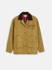 The Frontier Jacket In Canvas features a tan canvas body, brown corduroy collar, brown buttons, three front pockets, and a plaid flannel lining at the neckline, shown on a plain white background.