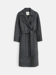 The Georgia Wrap Coat in Wool Alpaca is a long, dark gray coat featuring a wide lapel collar, long sleeves, and a matching belt at the waist. This elegant overcoat is shown on a white background.