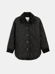 The Wembley Quilted Jacket features a black quilted design, relaxed fit, curved hem, front snap buttons, ribbed cuffs, detachable sherpa collar, and a neck label. It is displayed against a plain white background.