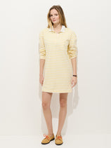 A woman with light brown hair and a neutral expression models the Lizzy Rugby Stripe Dress in Cotton Jersey against a white background, paired with tan shoes featuring orange laces, highlighting the dress’s feminine silhouette.