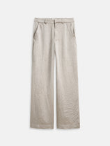 The Claire Pant is a beige, wide-leg party trouser for women, crafted from slightly shiny, wrinkled fabric. It features side pockets, belt loops, a fitted waistband with button closure, and is shown flat on a white background.