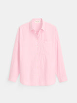 The Jo Shirt In Cotton Poplin is a light pink, long-sleeve button-up crafted from 100% cotton, featuring a single chest pocket and refined Troca shell buttons, shown laid flat on a plain white background.