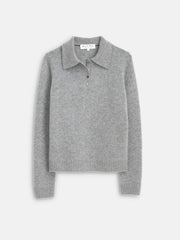 The Alice Polo In Cashmere is a light gray, long-sleeve sweater featuring ribbed cuffs and hem, a classic collar, and a three-button placket. The soft sweater is displayed flat on a plain white background.