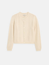 The Annalise Sweater in Wool is a cream-colored, long-sleeve cardigan featuring a chevron pattern, round neckline, ribbed cuffs and hem, and a button-down front. The sweater is laid flat on a white background.
