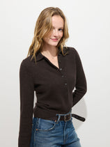 A woman with light brown hair, wearing the Park Polo in Washed Cashmere and blue jeans, stands against a plain white background, smiling slightly.